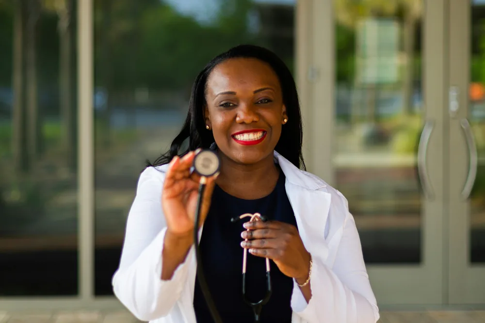 Une soignante souriante, stéthoscope à la main