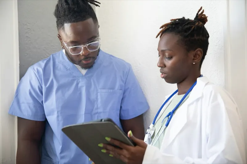Deux soignants consultent un dossier sur une tablette